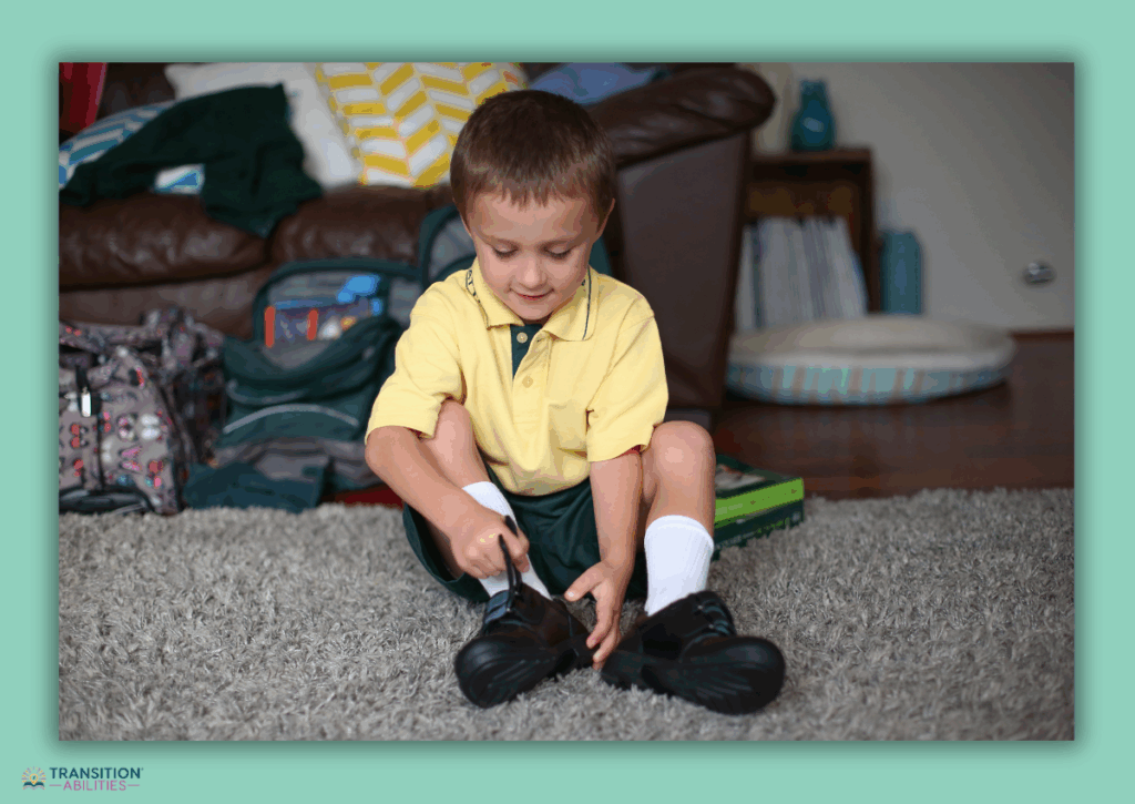 Child sitting on the floor putting on shoes.