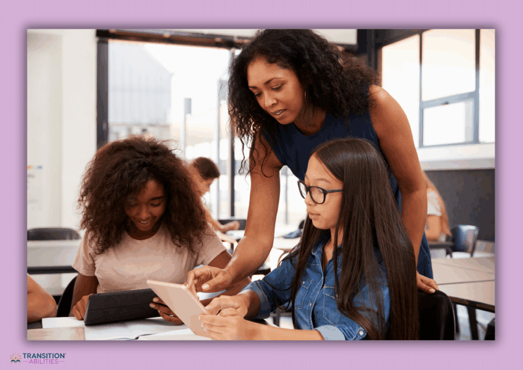 Teacher assisting two students using tablets in a classroom.