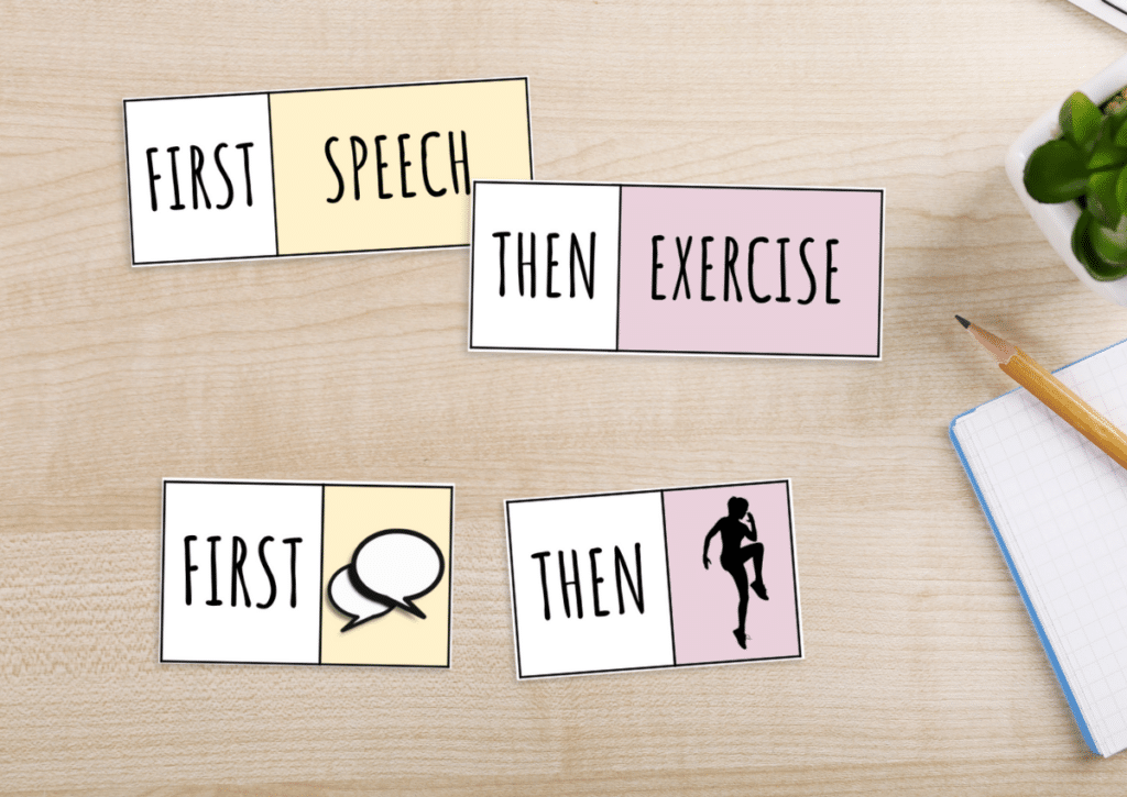 First-then visual schedule cards laid out on a wooden desk showing "First Speech, Then Exercise" with both words and matching icons.